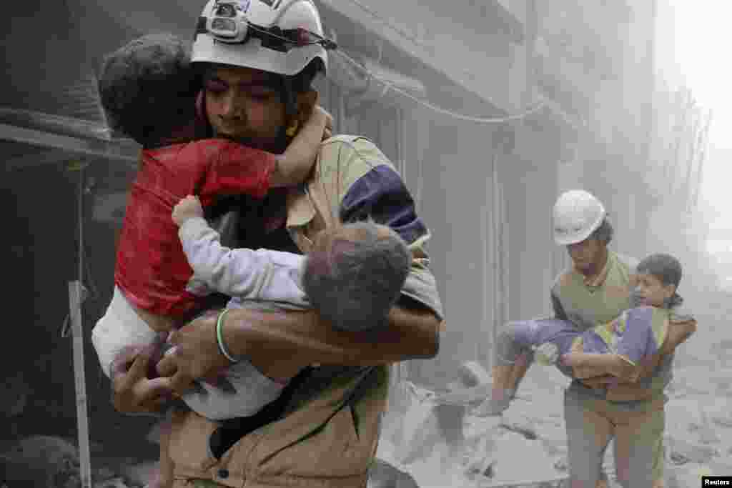 Các thành viên của lực lượng dân phòng giải cứu trẻ em sau vụ việc mà nhà hoạt động nói rằng một cuộc không kích của lực lượng trung thành với Tổng thống Syria Bashar al-Assad nhắm vào khu vực al- Shaar Aleppo.