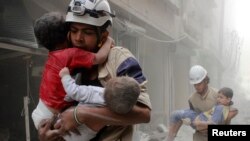 FILE - Members of the Civil Defence rescue children after what activists said was an air strike by forces loyal to Syria's President Bashar al-Assad in Aleppo.