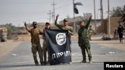 지난 3일 이라크 시아파 민병대 '민중동원군(PMF)'이 이슬람 수니파 무장세력 IS로부터 시리아 국경의 알콰임 지역을 탈환한 후 IS 깃발을 거꾸로 들고 승리를 자축하고 있다.