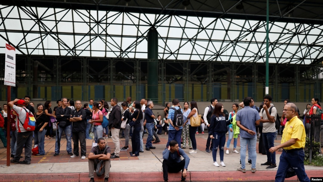 Para pengguna transportasi menunggu di luar stasiun kereta metro saat aliran listrik padam di Caracas, Venezuela, 22 Juli 2019. 