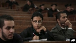 FILE - Mahinour el-Masry, an Egyptian activist, takes notes during a trial session of activists facing charges on organizing unauthorized protests, at a courtroom in Cairo, Egypt, Dec. 4, 2014..