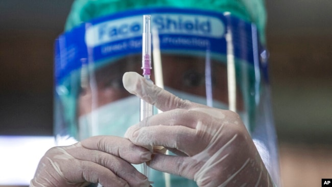 A health worker prepares a dose of the Sinovac COVID-19 vaccine for people who live in a popular market area where a new cluster of COVID-19 infections was found in Bangkok, Thailand, March 17, 2021.