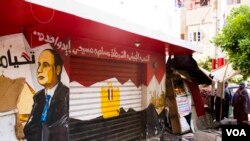 A store’s entrance in the church’s area is painted with Egyptian flag colors and president Sissi’s face and a banner reading: “The nation, military, police, Muslim and Christian are one hand,” Tanta, Egypt, Saturday, May 20, 2017. (H. Elrasam/VOA)