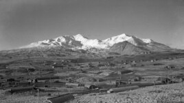 This 1947 photo shows the U.S. Army Williwaw camp on Alaska's Adak Island. Mount Moffett is in background. The Quonset huts are dug in as protection against the strong Aleutian winds. (AP Photo/Joseph D. Jamieson)