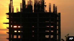 Construction workers work on a new building in Phnom Penh. Cambodia is embracing a thriving real estate market, where land and housing prices in the capital city skyrocket with no sign of letting up, file photo. 