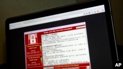 FILE - Screenshot of the warning screen from a purported ransomware attack, as captured by a computer user in Taiwan, is seen on laptop in Beijing, May 13, 2017.