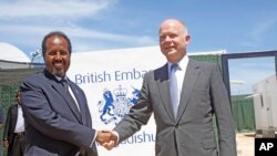 Le Secrétaire au Foreign Office, William Hague (à droite) serrant la main du président somalien, Hassan Sheikh Mohamud, à l'ouverture de l'ambassade britannique nouvellement construite dans la capitale somalienne Mogadiscio, le 25 avril 2013.
