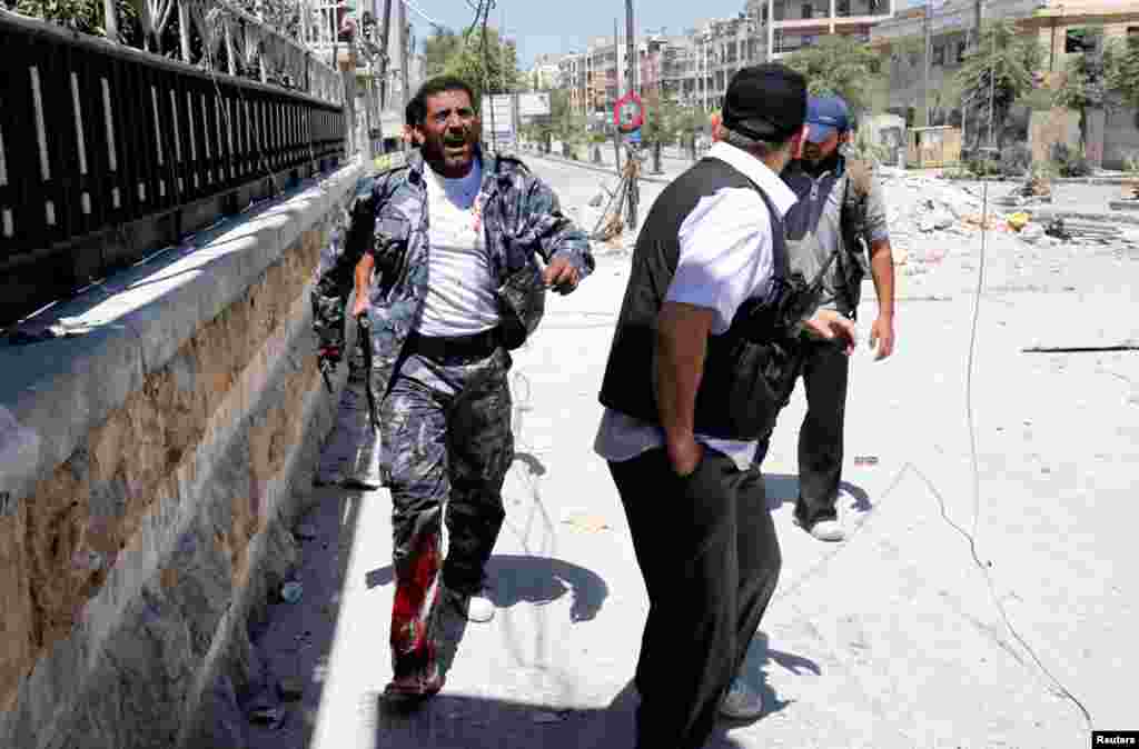 Free Syrian Army fighters run to take cover from fire from regime forces in the Seif El Dawla neighborhood of Aleppo, Syria, August 24, 2012.