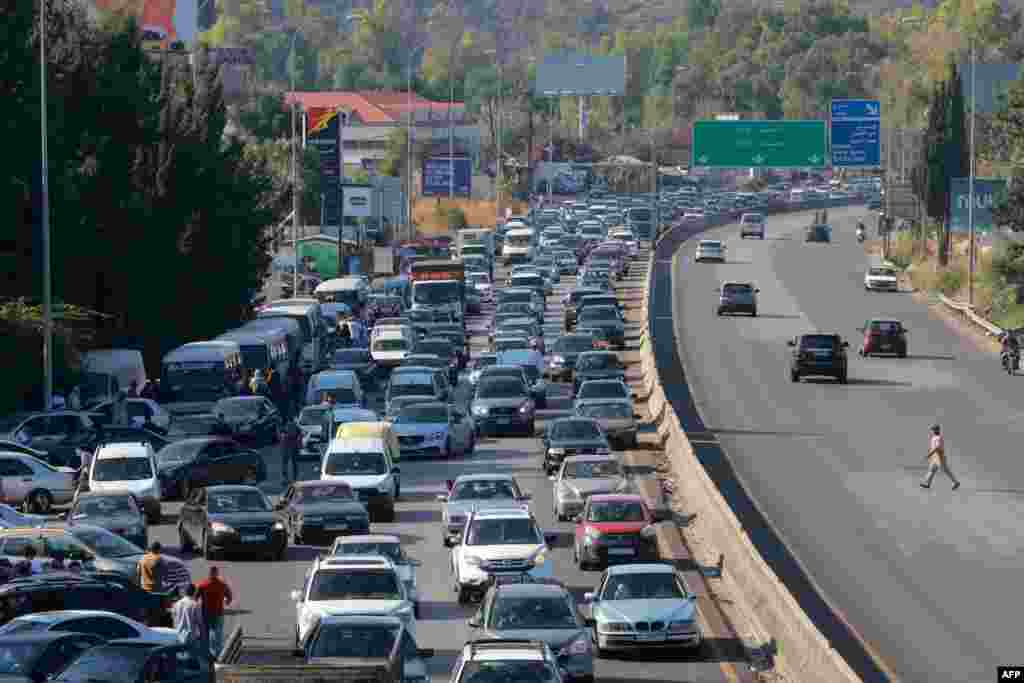 Vehicles wait in traffic in the town of Damour, south of the capital Beirut, as people flee southern Lebanon. Israel announced dozens of new airstrikes on Hezbollah strongholds in Lebanon on September 24.