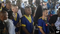 FILE - From left Tyler Thompson Jr., Marcel Malanga and Benjamin Reuben Zalman-Polun, right, all American citizens, face the court in Kinshasa with 52 other defendants on June 7, 2024.