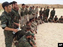 FILE - In this file photo taken May 21, 2016, members of what the U.S. calls the Syrian Democratic Forces gather after a training session at a firing range in northern Syria.