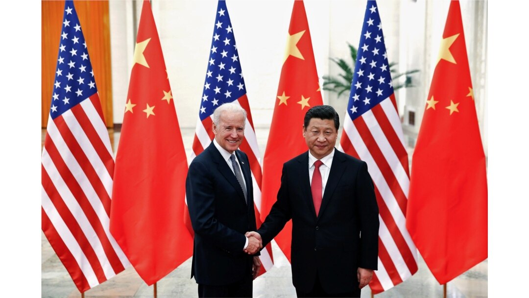 Presiden China Xi Jinping berjabat tangan dengan Joe Biden, yang saat itu masih menjabat sebagai Wapres AS(kiri) di dalam Aula Besar Rakyat di Beijing 4 Desember 2013. REUTERS/Lintao Zhang/Pool/File Photo