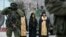 Orthodox monks pray next to armed servicemen near Russian army vehicles outside a Ukrainian border guard post in the Crimean town of Balaclava March 1, 2014. 