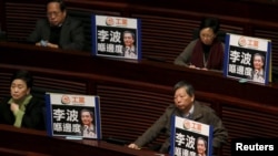 Pro-democracy lawmakers display portraits of Lee Bo, one of the five booksellers who disappeared from a local bookstore, as Chief Executive Leung Chun-ying speaks during his annual policy address at the Legislative Council in Hong Kong, Jan. 13, 2016. The