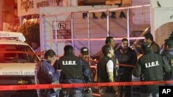 State police and forensic experts outside of a nightclub in Guadalajara, Mexico, after gunmen opened fire and hurled a grenade, February 12, 2011