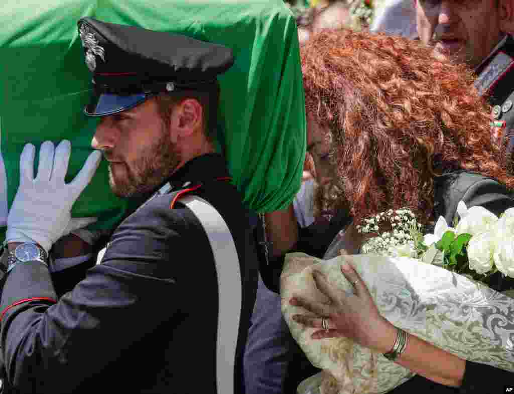 Carabinieri officer Mario Cerciello Rega&#39;s wife, Rosa Maria, right, follows the coffin of her husband during his funeral in Somma Vesuviana, near Naples, southern Italy.