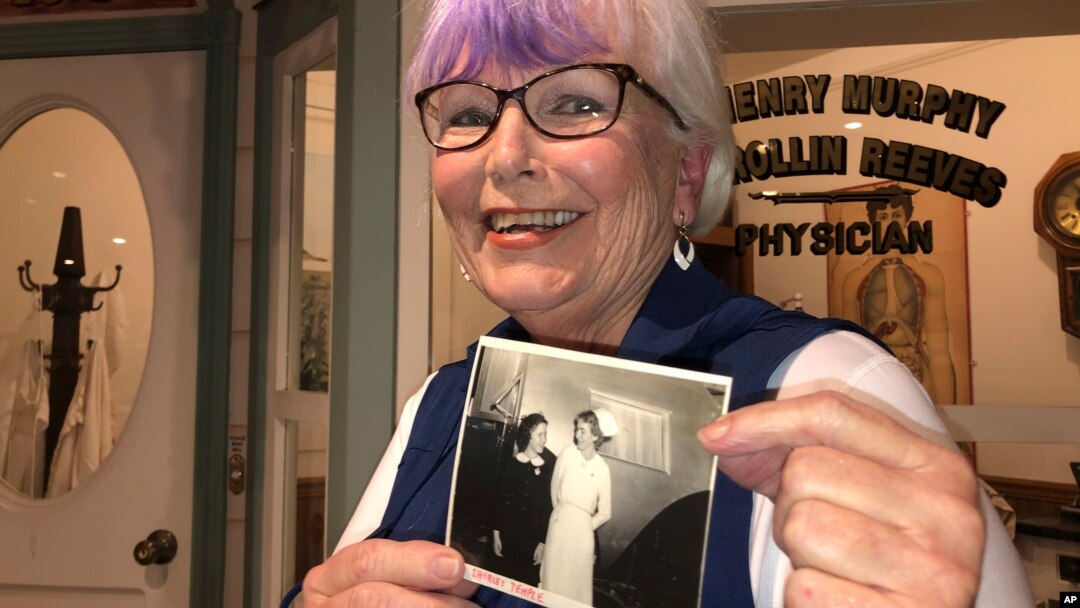 Nurse practitioner Sigrid Stokes, 76, holds a photograph of her mother talking to Shirley Temple, at the Salinas Valley Memorial Hospital in Salinas, Calif., Wednesday, Feb. 3, 2021. (AP Photo/Haven Daley)