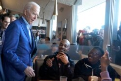 Democratic presidential candidate former Vice President Joe Biden talks with customers at the Buttercup Diner during a campaign stop in Oakland, Calif., March 3, 2020.