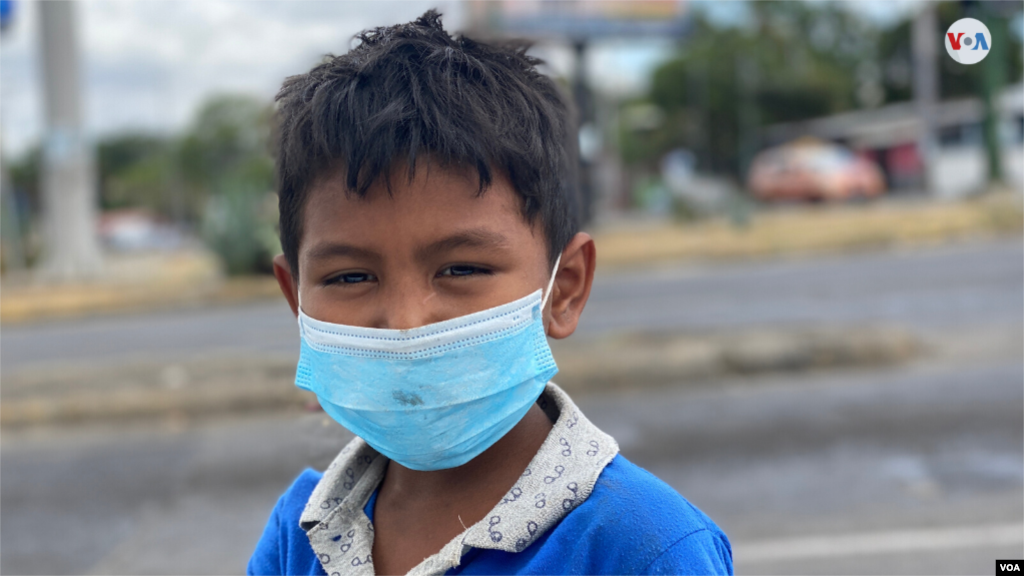 Un menor de edad que vive en extrema pobreza en Managua pide dinero en los semáforos de Managua usando mascarilla por el coronavirus. [Foto: Houston Castillo]