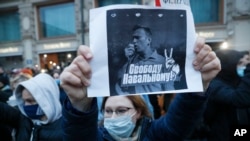 A activist holds up a poster reading "Freedom for Navalny!" during an opposition rally in support of jailed opposition leader Alexey Navalny, in Moscow, Russia, April 21, 2021.