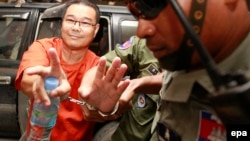 Cambodian opposition senator Hong Sok Hour (L) of the Sam Rainsy Party (SRP) is escorted by police officers at the Municipal Court in Phnom Penh, Cambodia, October 2, 2015. (Photo of EPA/MAK REMISSA) 