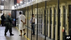 FILE - An inmate is led out of his cell at San Quentin State Prison in San Quentin, California, Aug. 16, 2016. A group of 114 Iraqis held in detention in the U.S. and due to be deported argue that their forcible repatriation and threats they would face in their homeland would run counter an international treaty against torture.