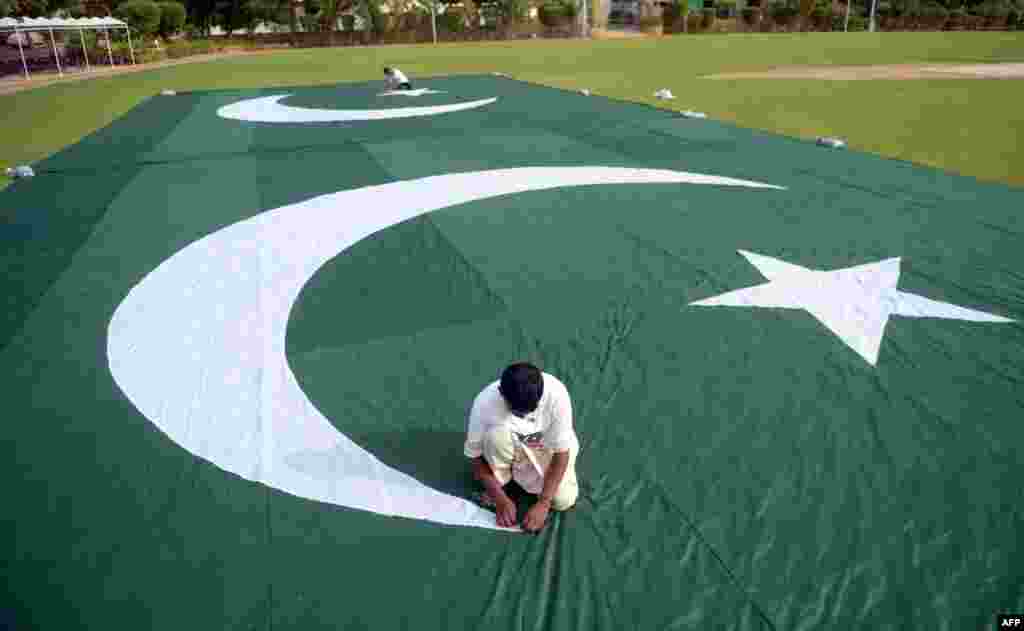 Pakistani workers make a huge national flag for the celebration of Independence Day in Karachi.&nbsp; Pakistan will celebrate its Independence Day on August 14.