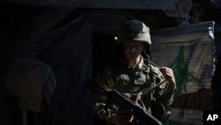 FILE: A Ukrainian soldier adjusts his rifle sling as he leaves his position on the line of separation from pro-Russian rebels near Shumy village, Ukraine, May 5, 2021. 