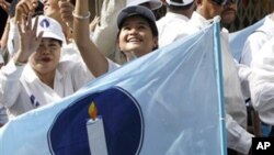 Supporters of the Sam Rainsy Party greet onlookers at a busy market during an election rally in Phnom Penh in 2008. 