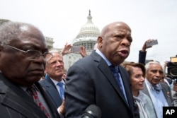 Rep. John Lewis, D-Ga., third from left, accompanied by fellow lawmakers, speaks on Capitol Hill in Washington after House Democrats ended their sit-in protest, June 23, 2016.