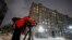 A cameraman works in front of the building housing an office of the German Deutsche Welle TV channel in Moscow, Russia, February 3, 2022. The Russian Foreign Ministry said the Moscow office of Deutsche Welle must close. (Yuri Kochetkov/EPA-EFE)
