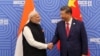 Perdana Menteri India Narendra Modi berjabat tangan dengan Presiden China Xi Jinping sebelum pertemuan mereka di sela-sela KTT BRICS di Kazan, Rusia, 23 Oktober 2024. (Biro Informasi Pers India/Handout via REUTERS)