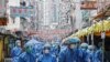 Health workers are seen in protective gear inside a locked down portion of the Jordan residential area to contain the COVID-19 in Hong Kong, Jan. 23, 2021.