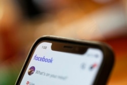 FILE - An iPhone displays a Facebook page, Aug. 11, 2019. Facebook said March 24, 2021, that hackers in China had used fake accounts and impostor websites in a bid to break into the phones of Uyghur Muslims.
