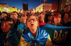 People attend a rally against recent approval of a new deal between Ukraine and Russia-backed separatists in Kyiv, Ukraine, Oct. 2, 2019.