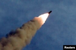 FILE - A missile is fired during the test of a multiple rocket launcher in this undated photo released Aug. 25, 2019, by North Korea's Korean Central News Agency.
