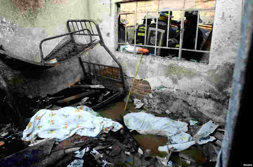 Bodies of victims of the explosion of a gas tanker truck are seen amidst the rubble of a destroyed house in San Pedro Xalostoc, on the outskirts of Mexico City, May 7, 2013.