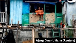 Seorang perempuan lansia di dalam rumahnya yang kumuh di tengah pandemi virus corona, di Jakarta, 4 Agustus 2020. (Foto: Ajeng Dinar Ulfiana/Reuters)