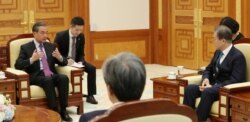 FILE - Chinese Foreign Minister Wang Yi talks with South Korean President Moon Jae-in during their meeting at the Presidential Blue House in Seoul, Dec. 5, 2019.