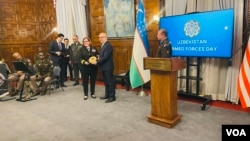 Rear Admiral Erin Osborne, one of the officials for Central Asia at the U.S. Department of Defense, receives a souvenir from Uzbekistan Ambassador Furqat Sidikov, at the Uzbek Embassy in Washington, Jan. 31, 2025.