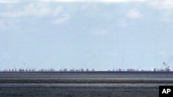 FILE - The alleged on-going reclamation of Subi Reef by China is seen from Pag-asa Island in the Spratly Islands in the South China Sea, western Palawan Province, Philippines, May 11, 2015.