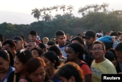 Venezuelans liIne up as they cross the Colombian-Venezuelan border over the Simon Bolivar International Bridge outskirts of Cucuta, Colombia Feb. 13, 2019.