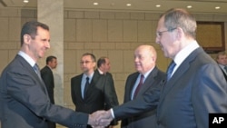 Syrian President Bashar al-Assad (L), shakes hands with Russian Foreign Minister Sergey Lavrov (R), as Russian Foreign Intelligence chief Mikhail Fradkov (2nd R) looks on during their meeting in Damascus, Syria, February 7, 2012.
