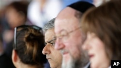 London’s newly elected mayor, Sadiq Khan, center, sits with Ephraim Mirvis, Chief Rabbi of the United Hebrew Congregations of the Commonwealth, at the Yom HaShoah ceremony at Barnet Copthall Stadium in London, Sunday May 8, 2016. Khan joined an annual memorial to the millions of Jews slain in the Holocaust as his first official act as mayor. (Yui Mok/PA via AP)