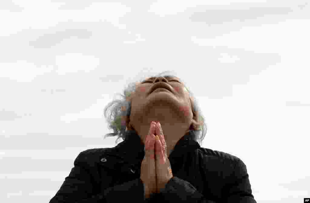 A weeping relative of a passenger aboard the sunken Sewol ferry prays as she awaits news on her missing loved one at a port in Jindo, South Korea.