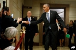 President Barack Obama shakes hands with bystanders as he leaves a meeting about his signature healthcare law with members of Congress, Jan. 4, 2017 on Capitol Hill in Washington.