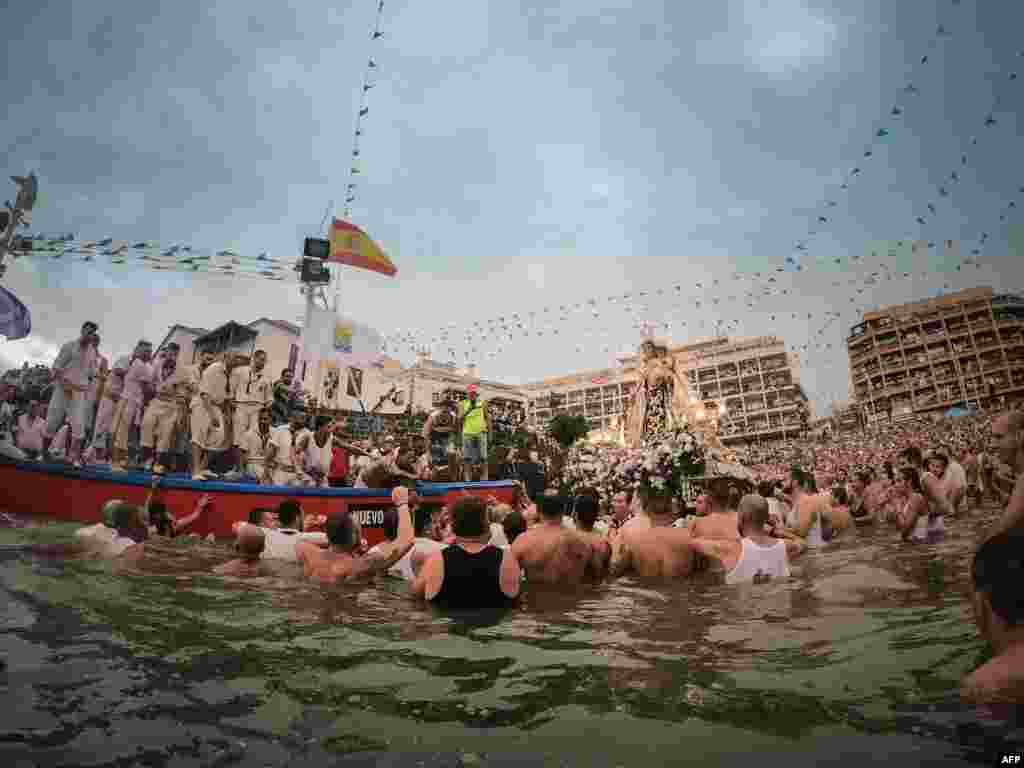 Costaleros of the Brotherhood of the Great Power carry the image of the Virgin del Carmen to a fishing boat while thousands of people observe them, on the Spanish Canary Island of Tenerife, July 16, 2019.