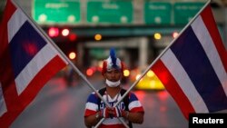 Seorang pendemo anti-pemerintah menggunakan pakaian berwarna bendera Thailand.