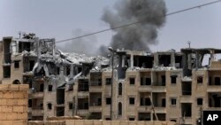 FILE - Smoke rises from a coalition airstrike on an Islamic State position, on the front line on the western side of Raqqa, northeast Syria, July 17, 2017.