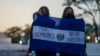 ARCHIVO - Miembros de un grupo feminista sostienen una bandera de El Salvador que dice en español: "Sin democracia no hay derechos", durante una protesta el 5 de febrero de 2024. 